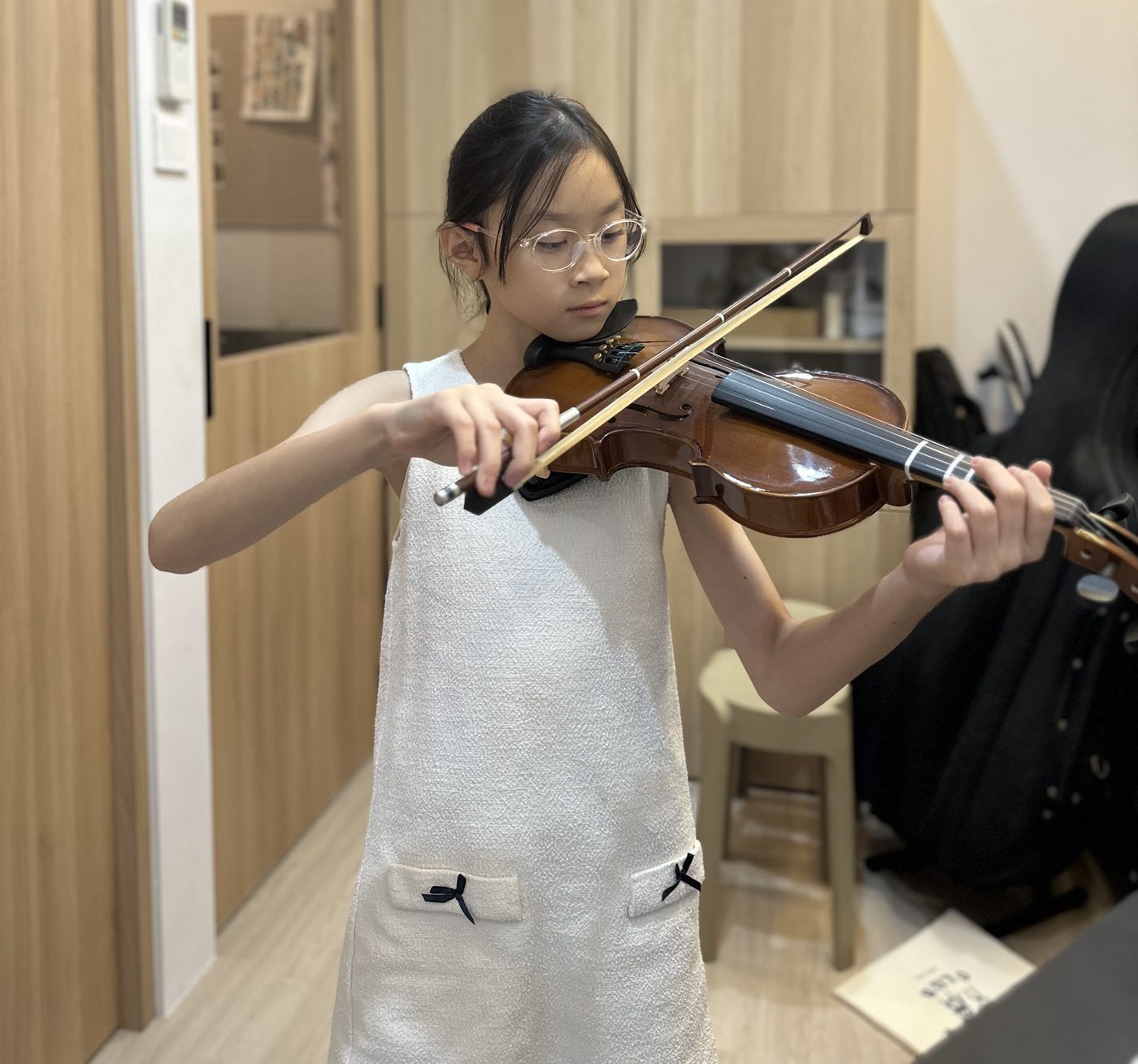 A young student in a private violin lesson at the studio