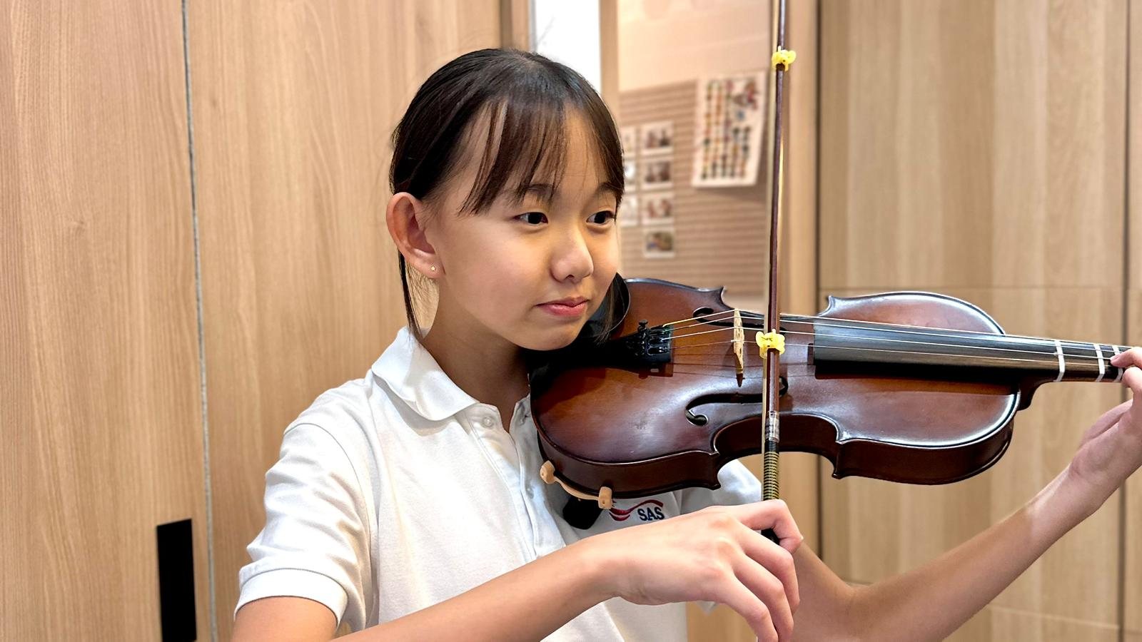 A young violin student in a lesson